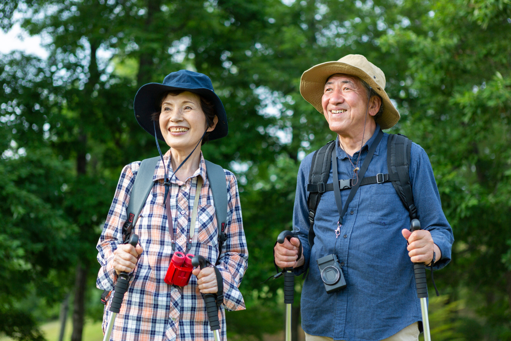 Elderly couple smiling and hiking