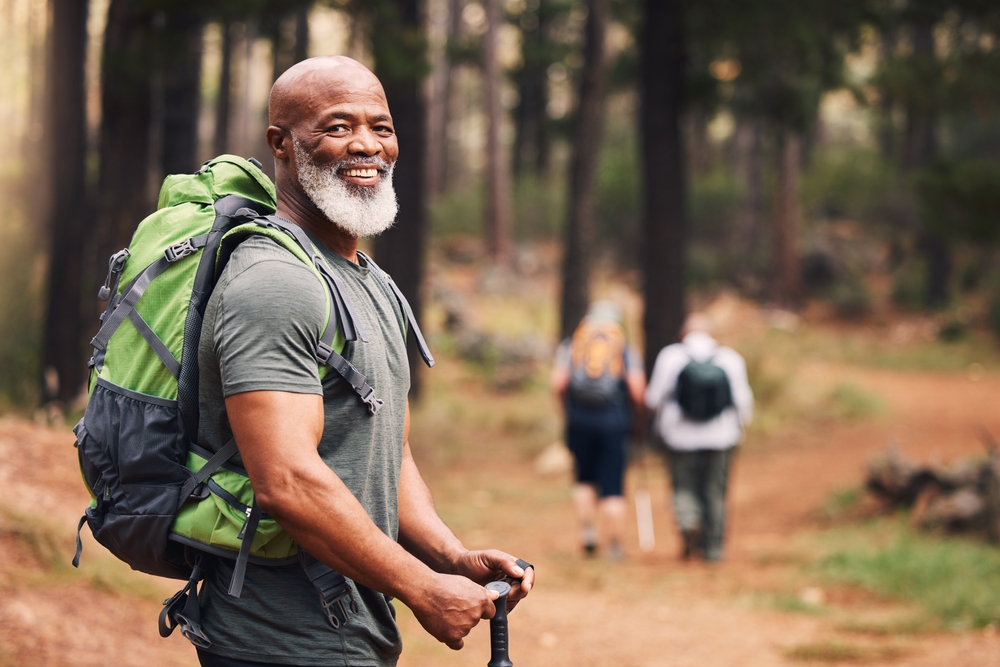 Senior man smiling and hiking with group of friends