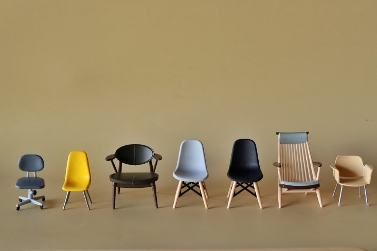 different chairs lined up with brown background