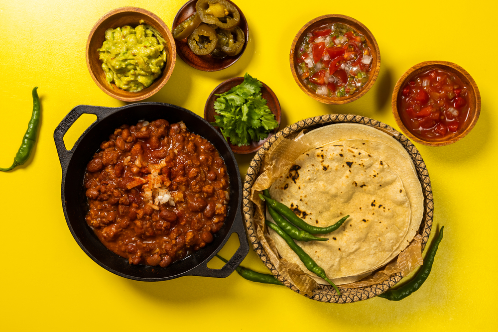 Various Mexican foods spread out on a yellow background